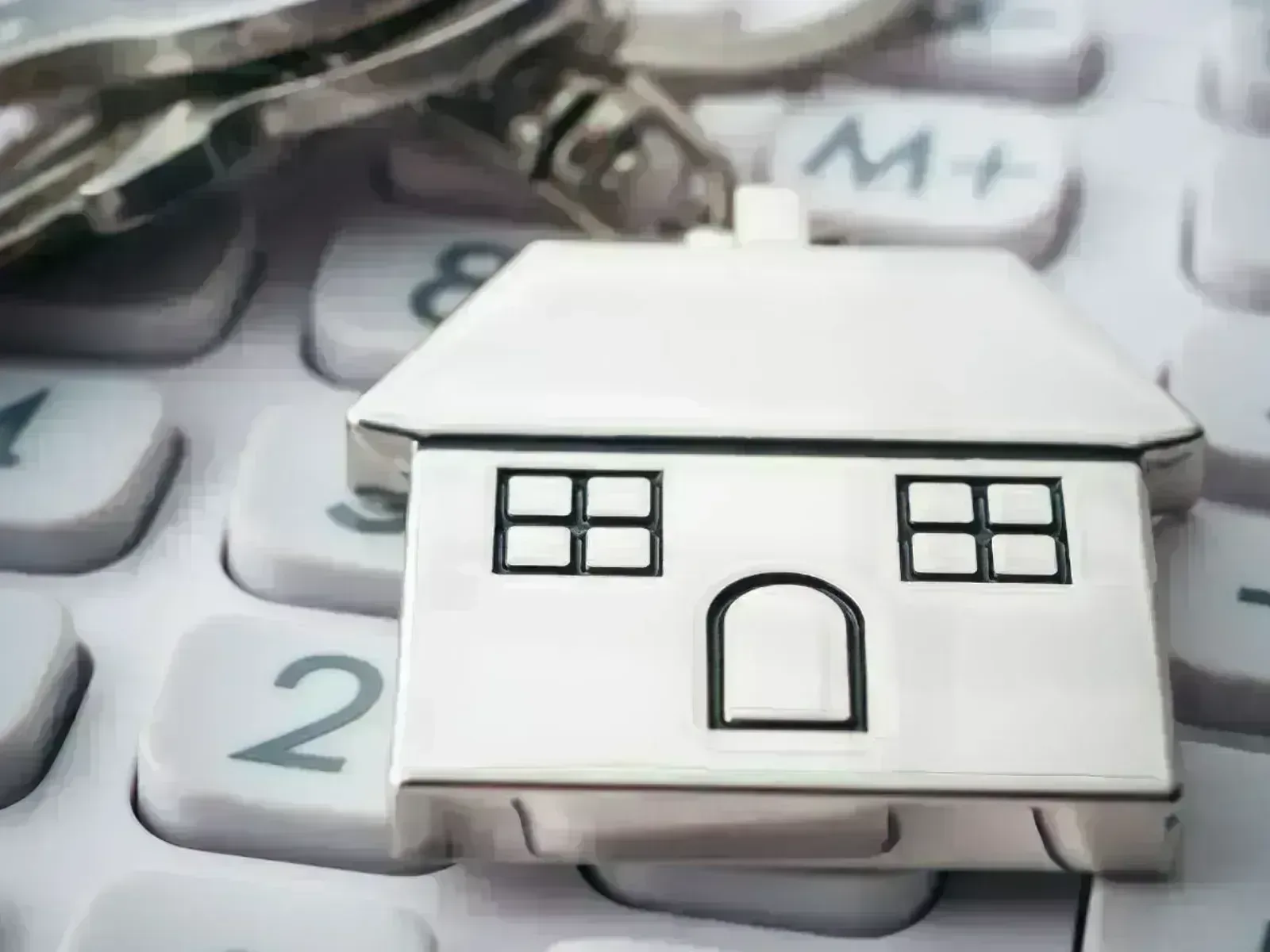 Llavero en forma de casa sobre calculadora: de la simulación a la oferta real con Hipoteca 100