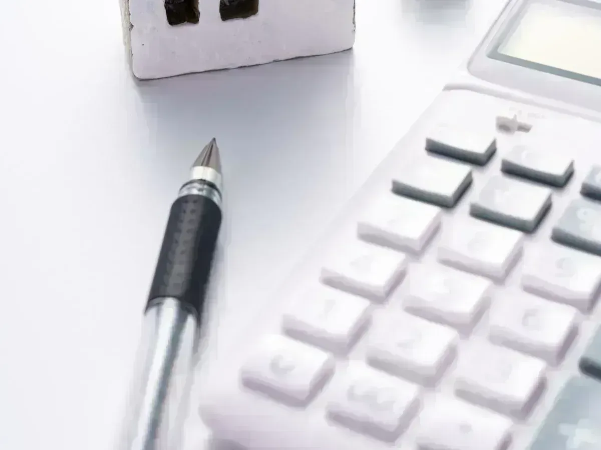 Casas en miniatura junto a una calculadora: estima qué vivienda puedes permitirte en Málaga