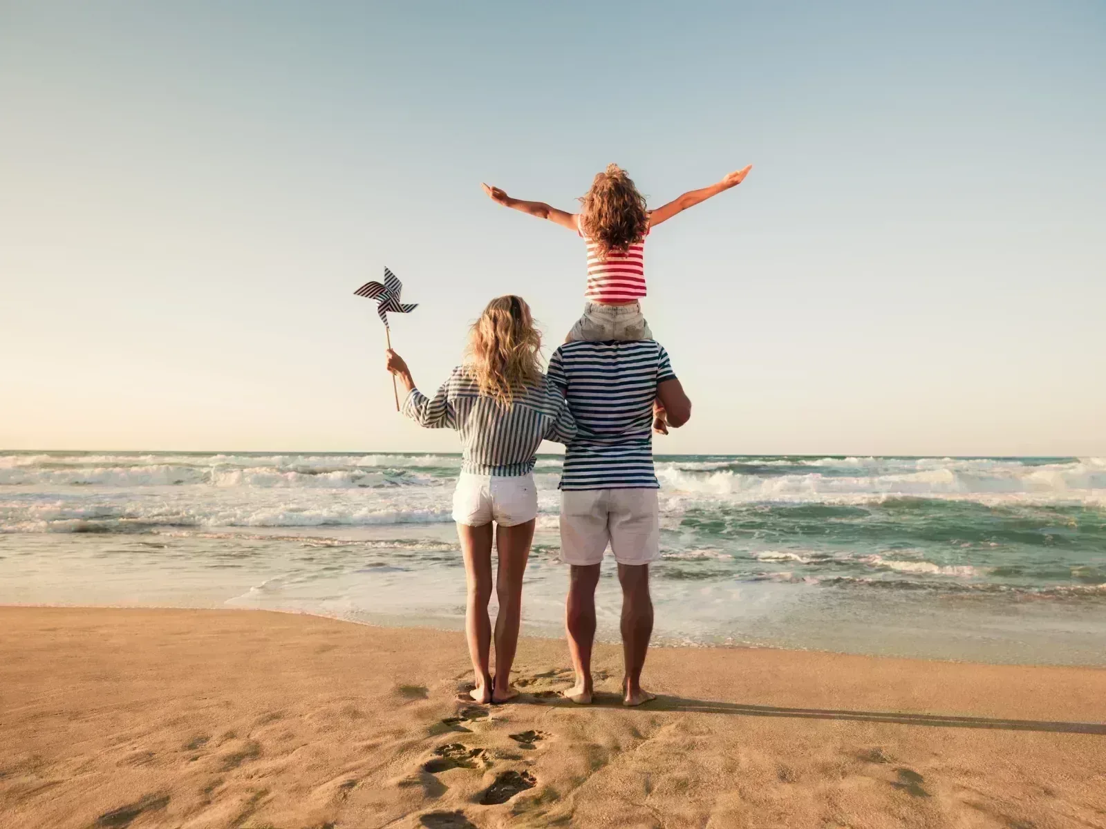 Familia en la playa: el ahorro mensual tras cambiar de banco se traduce en más tranquilidad